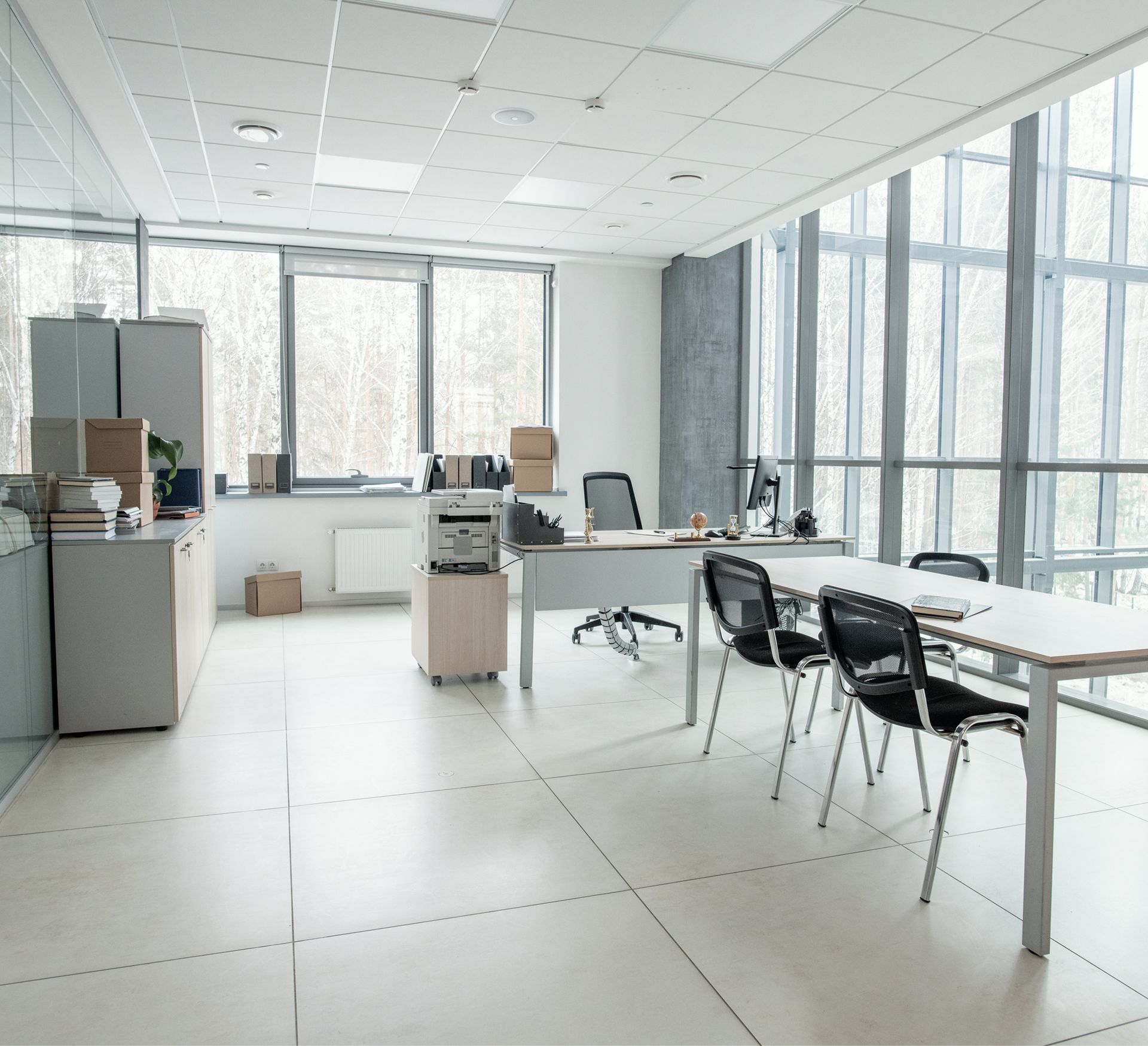 An office with a lot of windows and tables and chairs