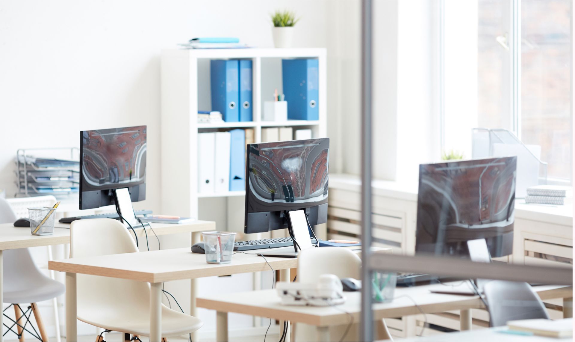 An empty office with tables , chairs , and computers.