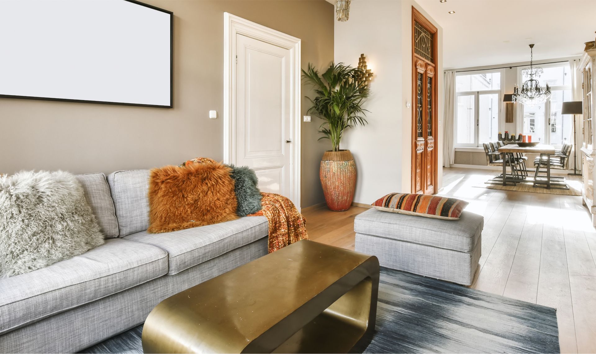 A living room with a couch , coffee table and ottoman.