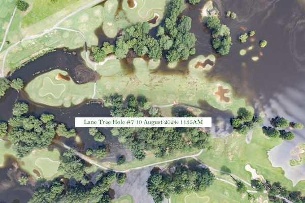 An aerial view of a golf course with a river running through it