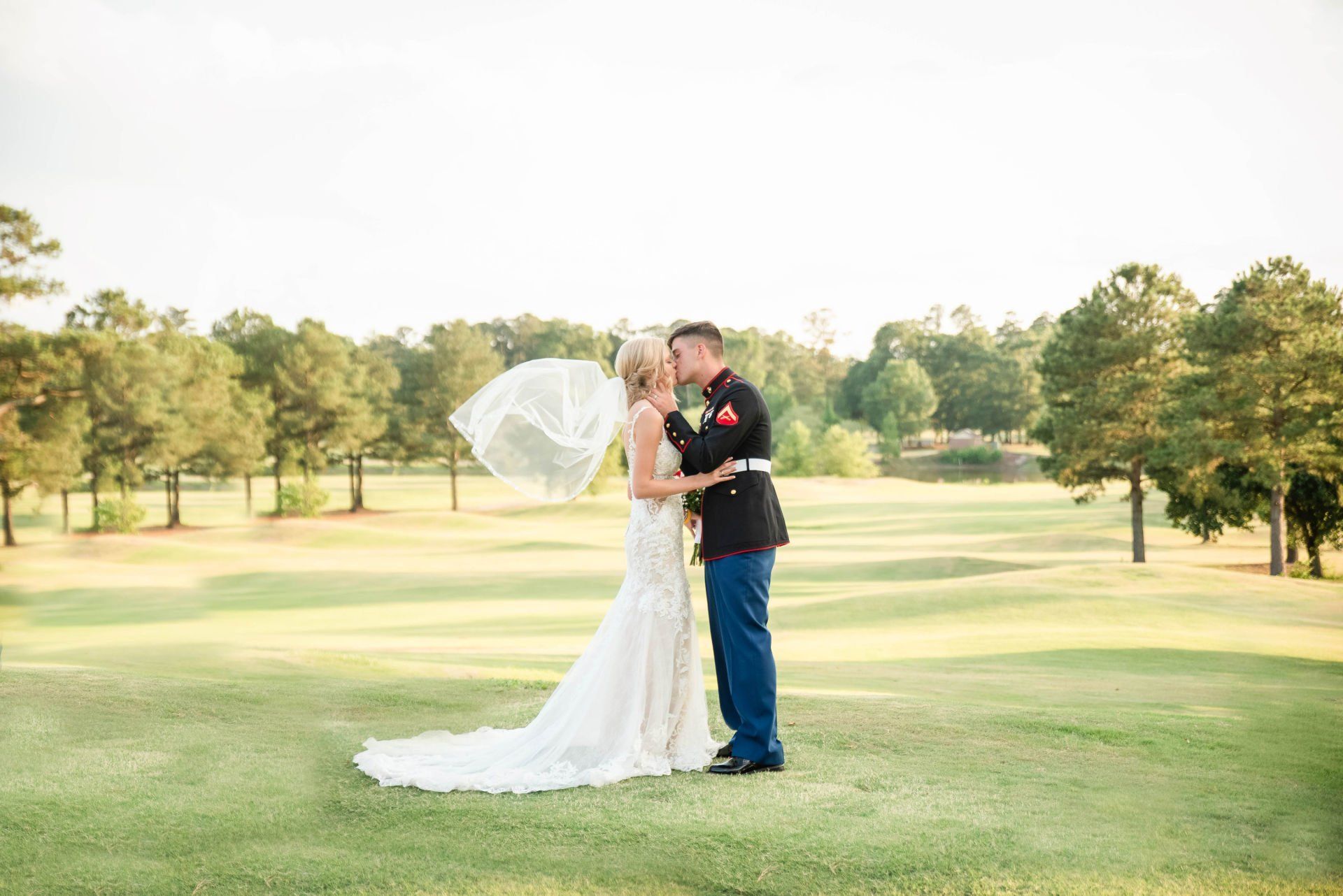 A bride and groom are kissing on a golf course. A bride and groom are kissing on a golf course.
