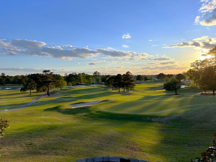 A man is putting a golf ball on a golf course. A man is putting a golf ball on a golf course.