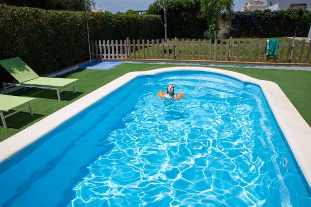 A person is floating on a raft in a swimming pool.
