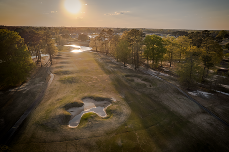An aerial view of a golf course at sunset.