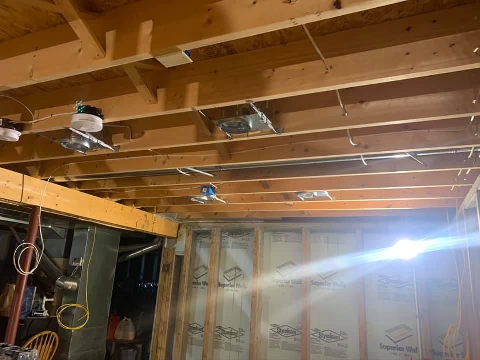 Garage ceiling with exposed beams, ceiling fans, and insulation between studs; construction in progress.