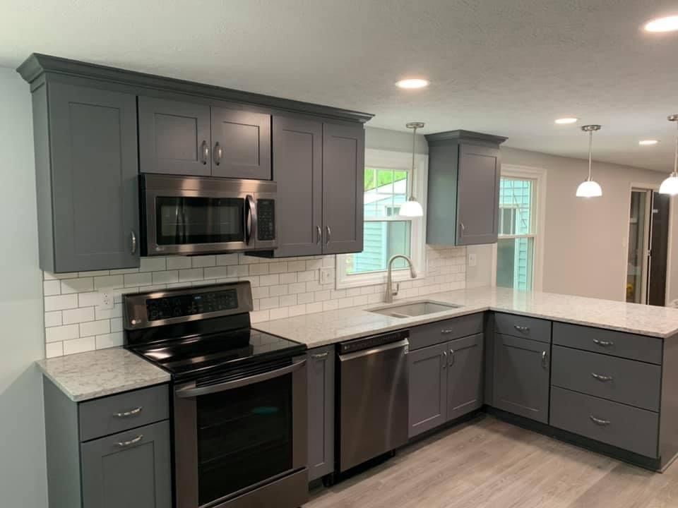 Modern kitchen with black and stainless steel appliances, subway tile backsplash, smokey gray Shaker cabinets, and all new lighting, paint and flooring.