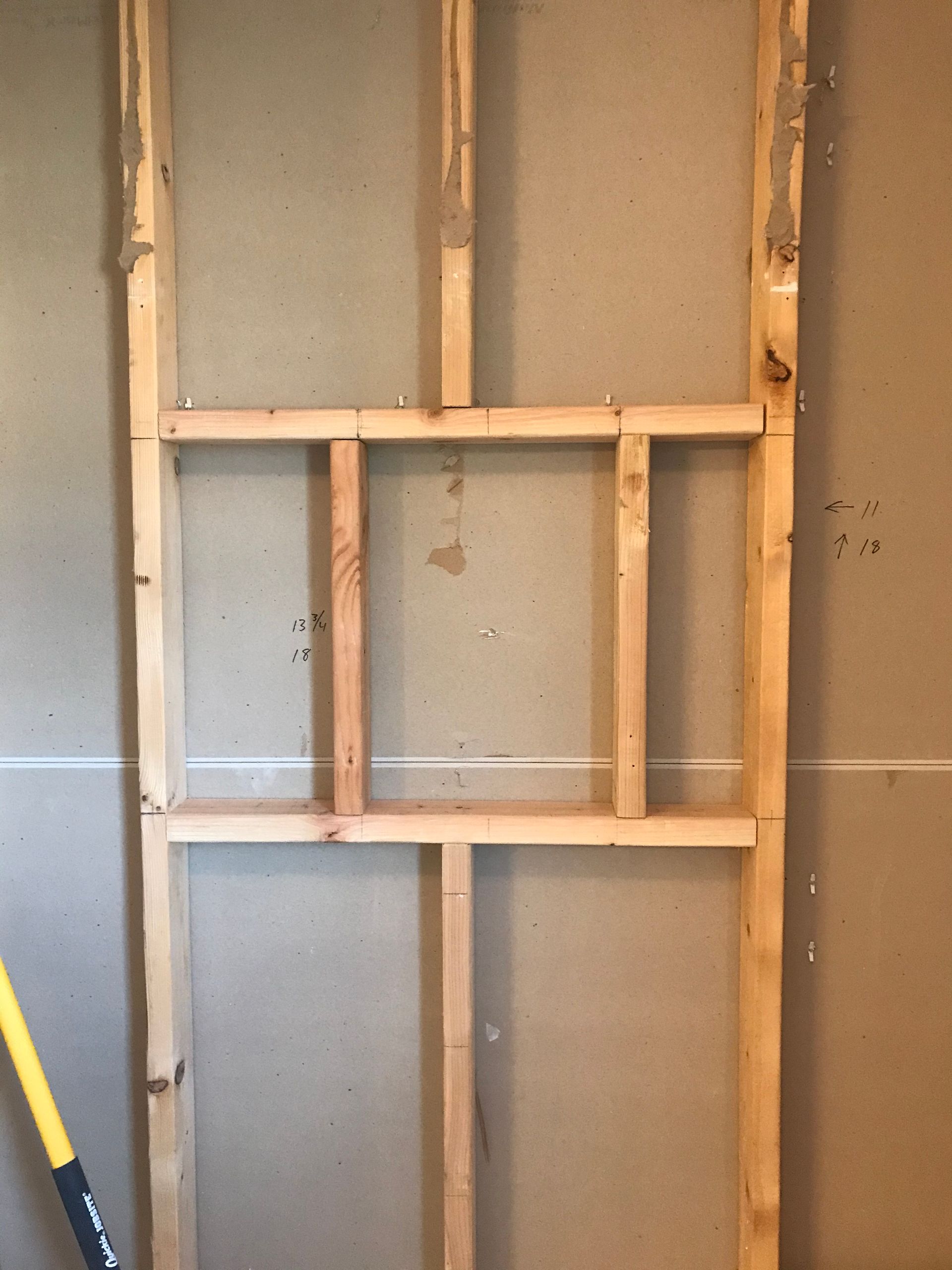 Wooden frame built into a wall, likely for a recessed shelf or opening.