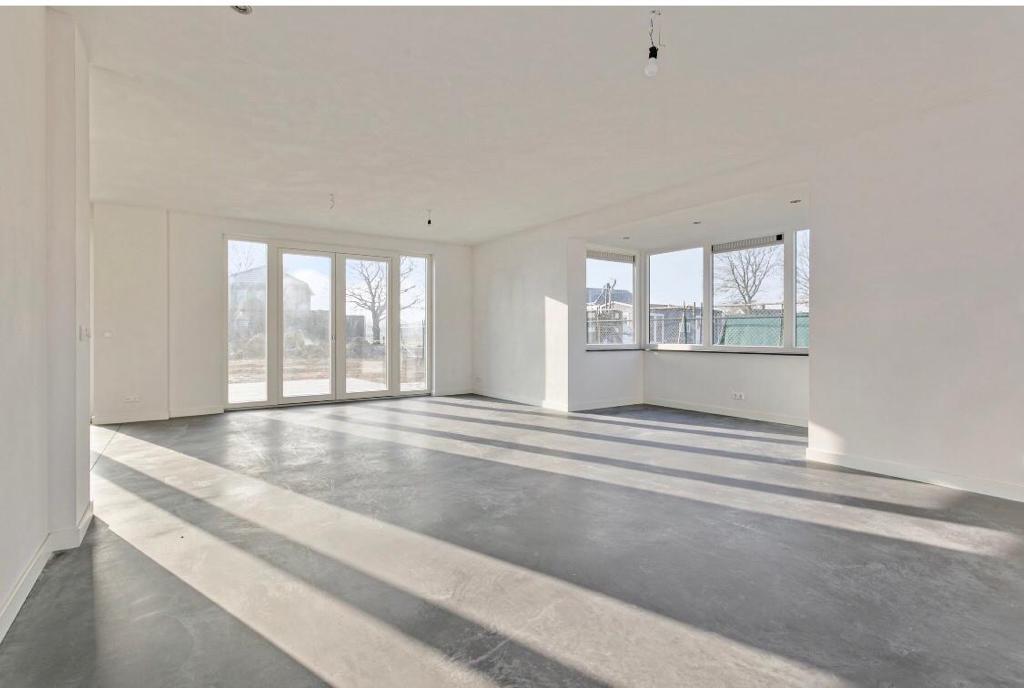 gestucte woonkamer met grote ramen en pui