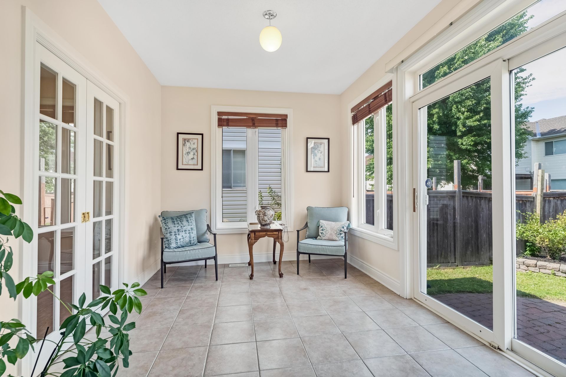 A living room with a couch and a wooden table with a vase of flowers on it.