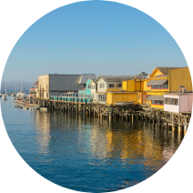 A row of houses on stilts next to a body of water.