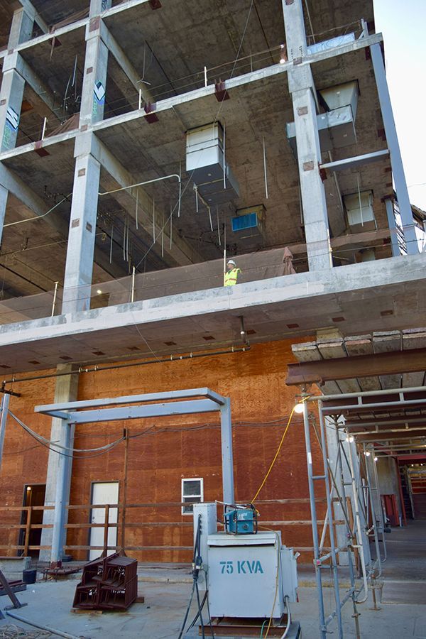 A building under construction with a lot of balconies and railings