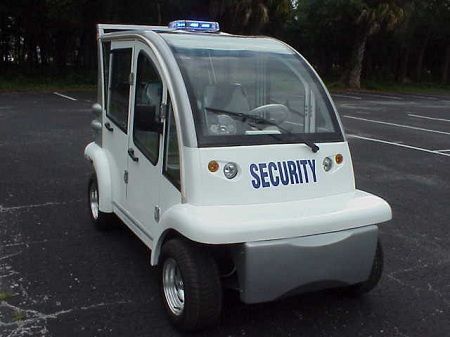 A white security vehicle is parked in a parking lot