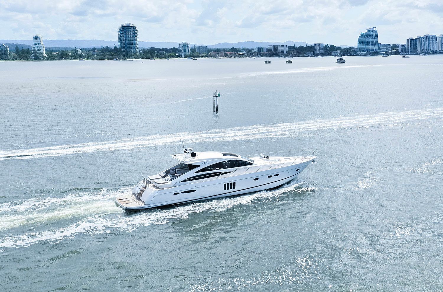 A large white yacht is docked in the water with two kayaks attached to it.