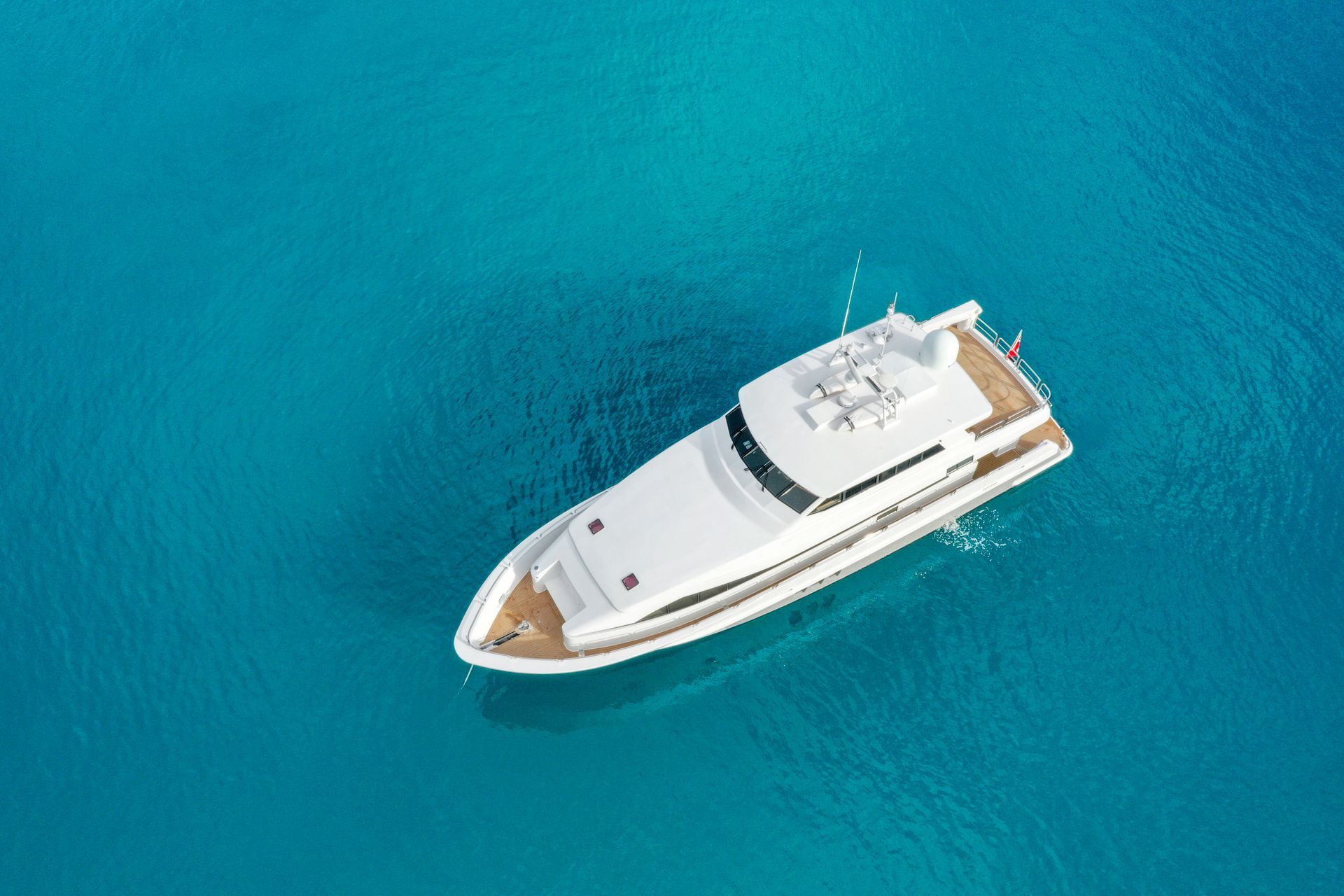 A large white yacht is floating on top of a large body of water.