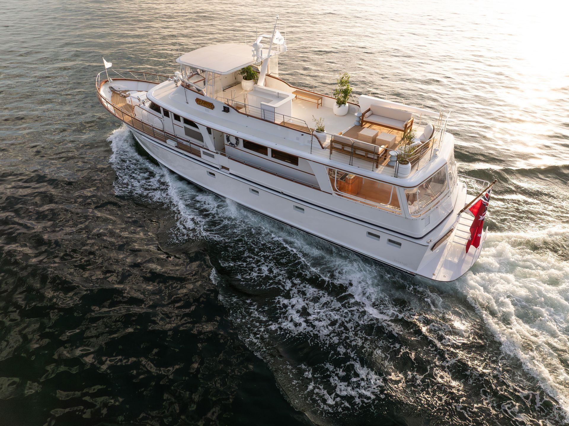 White yacht cruising on water, rear view.