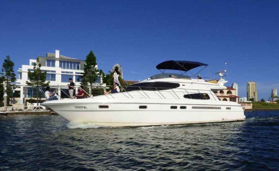 A white yacht is docked in a marina with other boats.
