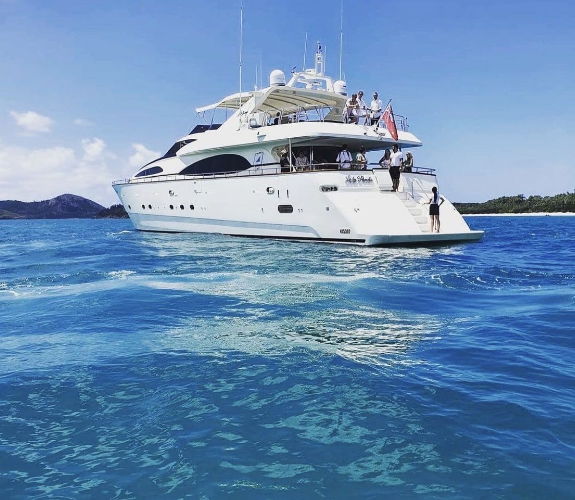 A large white yacht is floating on top of a large body of water.
