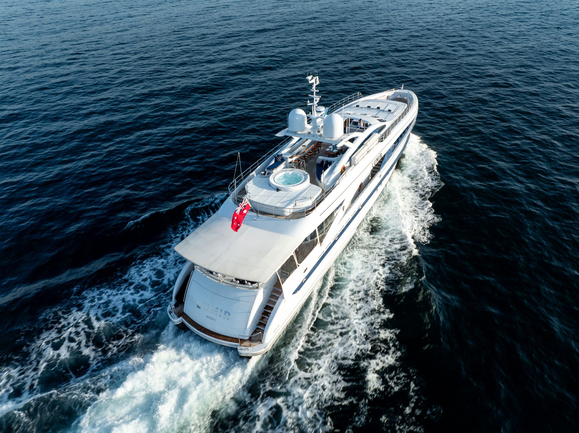 A large white yacht is floating on top of a large body of water.