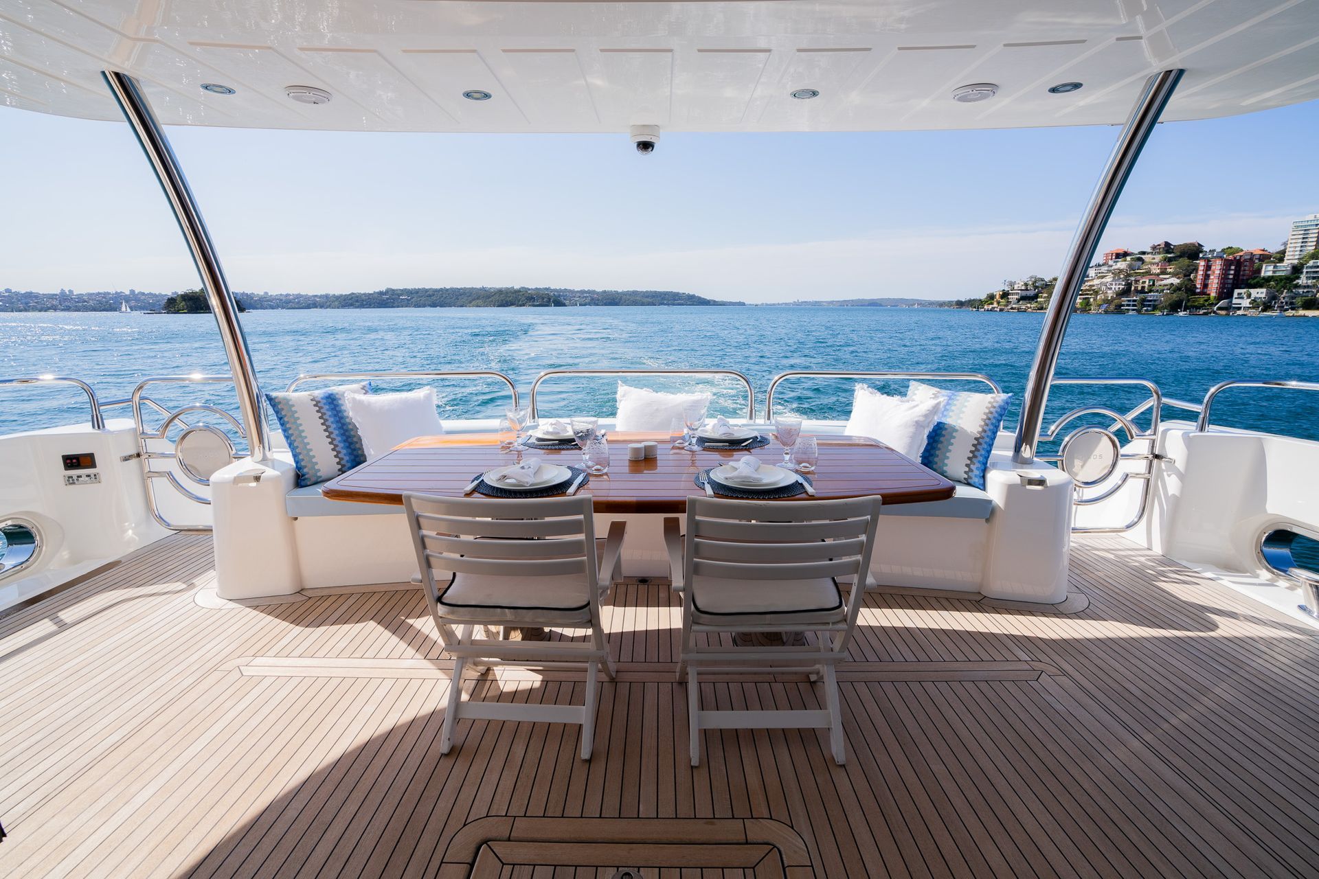 There is a table and chairs on the deck of a boat.