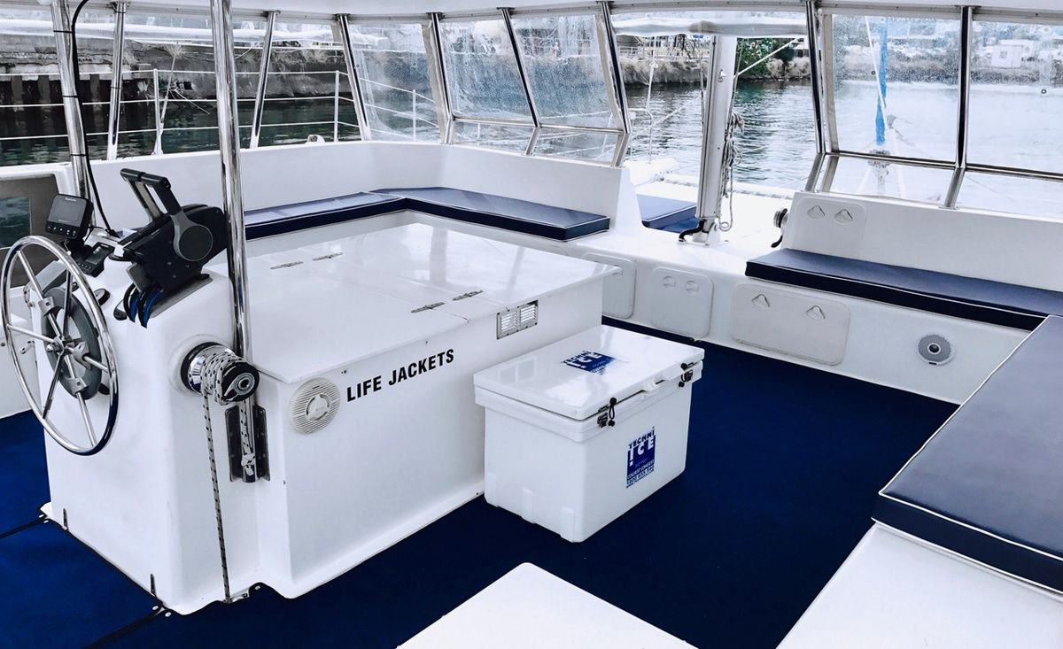 A white sailboat is floating on top of a body of water.