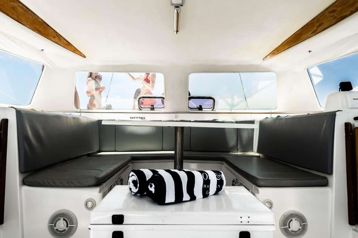 A group of people are standing on a sailboat in the ocean.