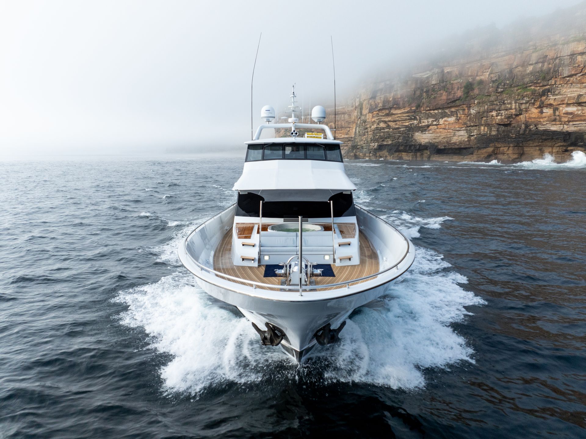 A large white yacht is floating on top of a body of water.