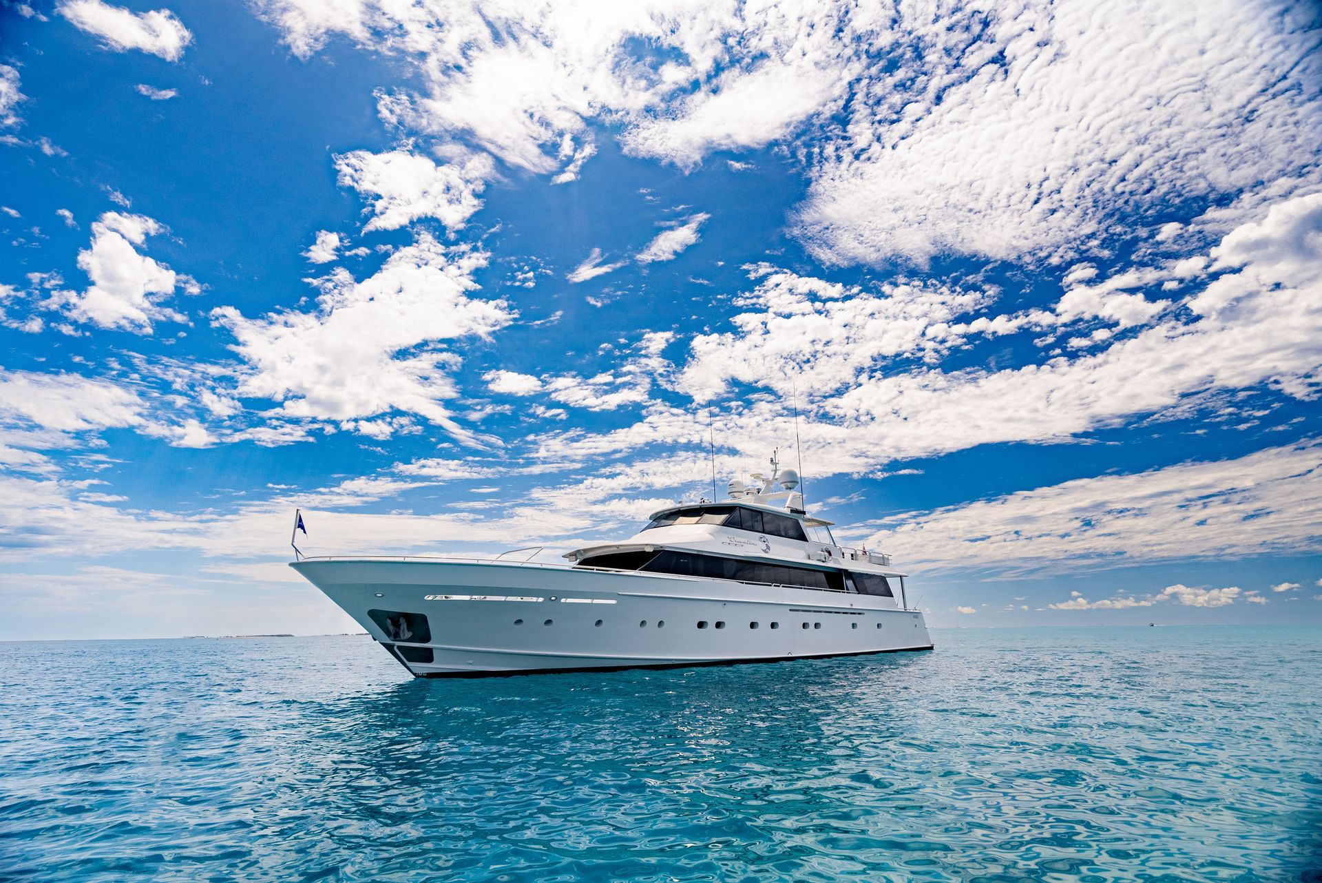 A large white yacht is floating on top of a large body of water.