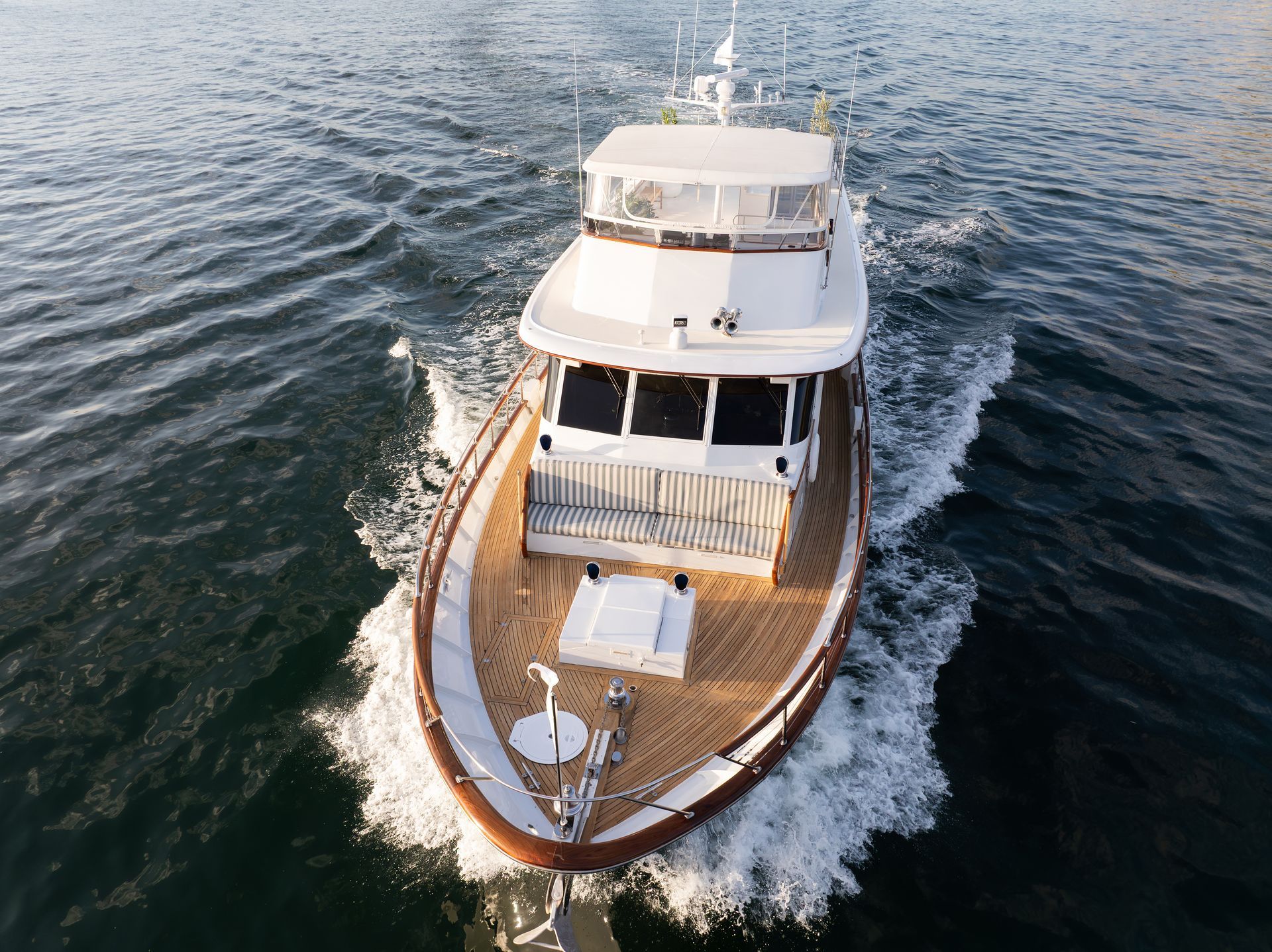 White yacht cruising on water, rear view.