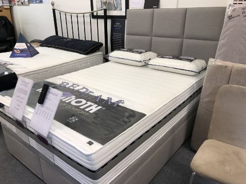 A bed with a mattress on top of it in a store.