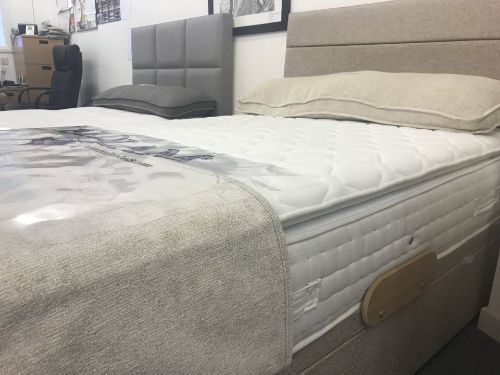 A bed with a mattress and pillows on it in a room.