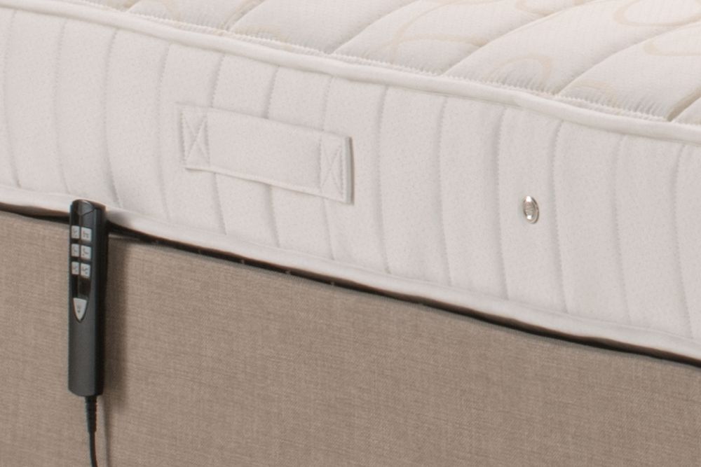 A mattress with a remote control attached to it.