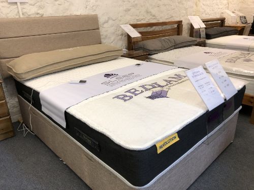 A bed with a mattress on top of it in a store.