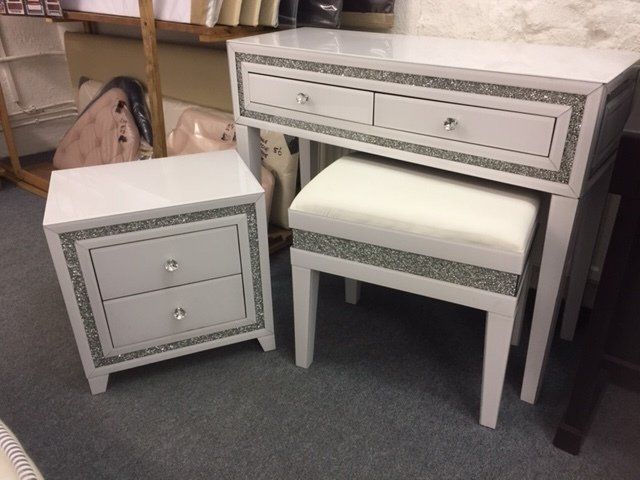 A dressing table with a nightstand and a stool