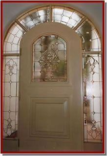 Vitral con una figura vestida con una túnica en el centro, ubicado en el interior de una iglesia.