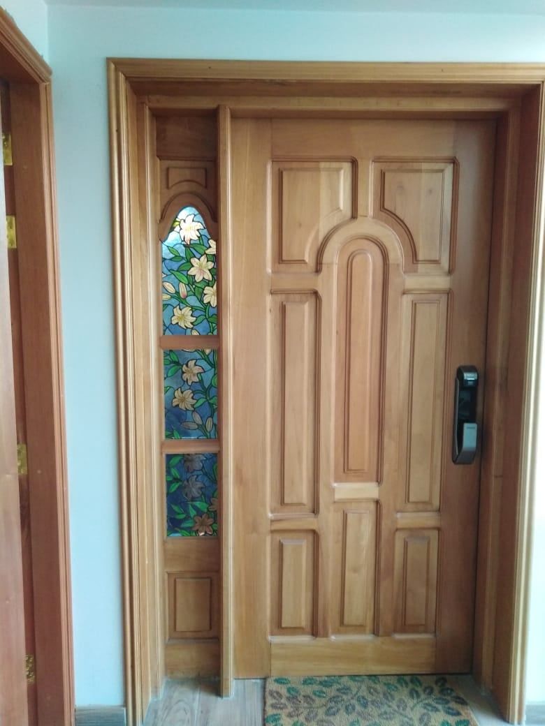 Una persona con delantal coloca piezas de vidrio de colores sobre una mesa de trabajo en un estudio.