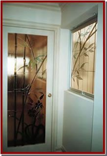 Manos enguantadas pintando un colorido panel de vidrieras sobre un banco de trabajo de madera.