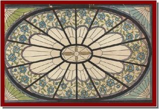 Manos enguantadas pintando un colorido panel de vidrieras sobre un banco de trabajo de madera.