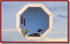 Manos enguantadas pintando un colorido panel de vidrieras sobre un banco de trabajo de madera.