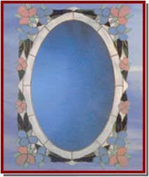 Vitral con una figura vestida con una túnica en el centro, ubicado en el interior de una iglesia.