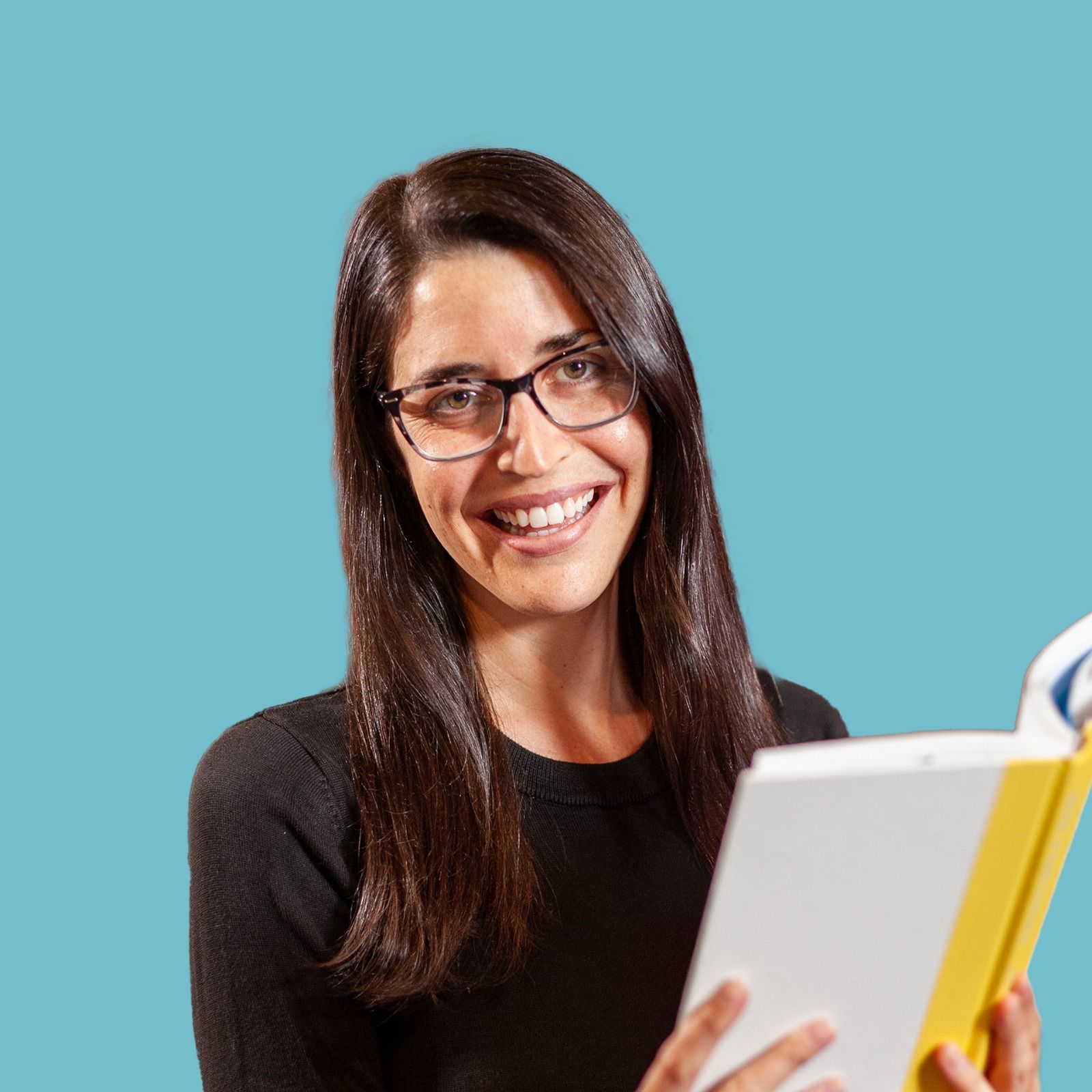 Woman with glasses gives a gift box tied with a peach bow. Pastel balloons in background.