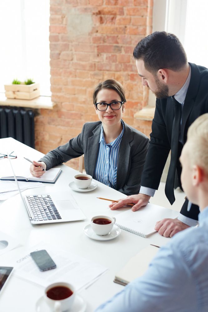 A group of people are sitting around a table having a meeting.