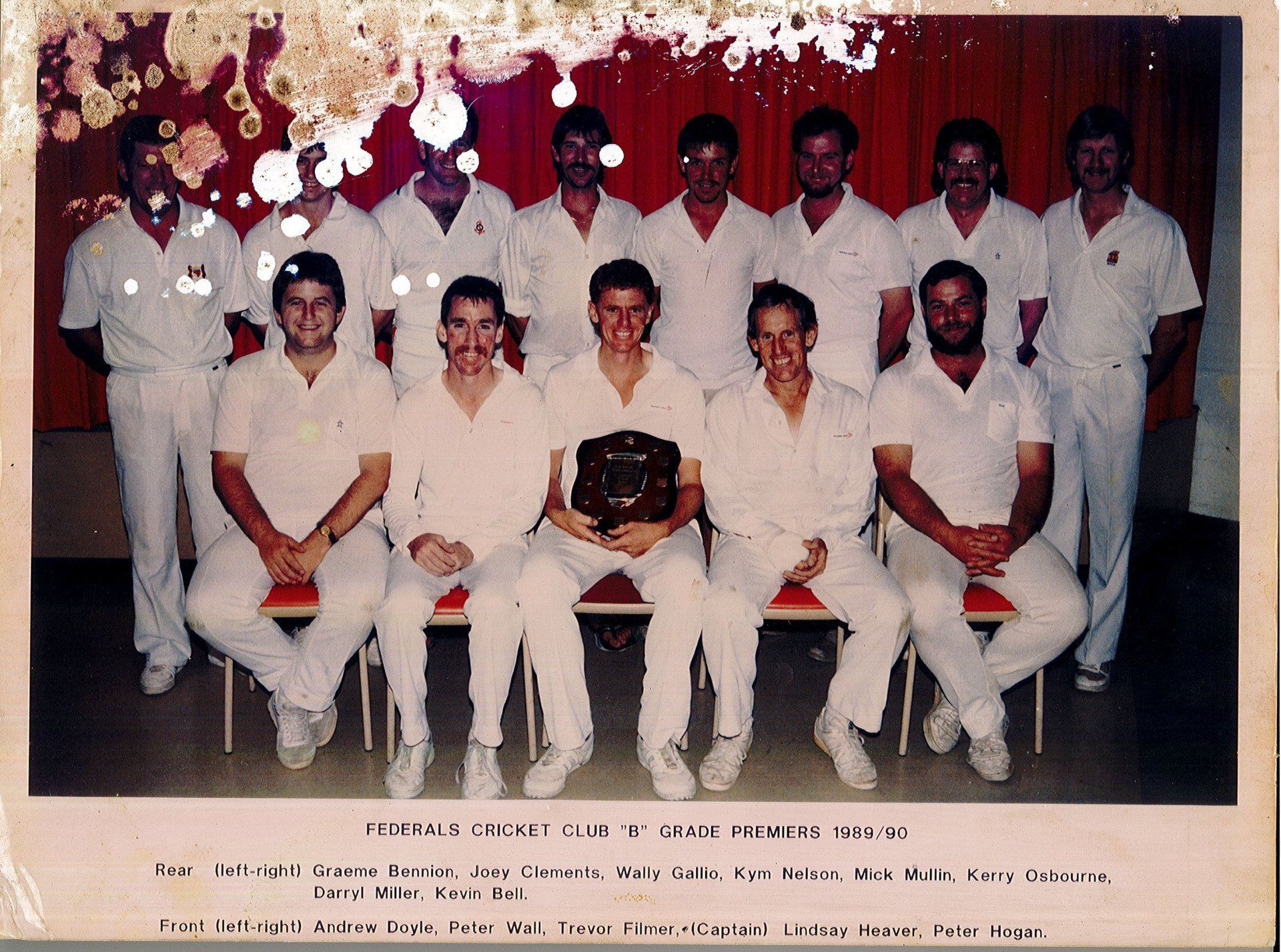 A group of men in white uniforms pose for a photo