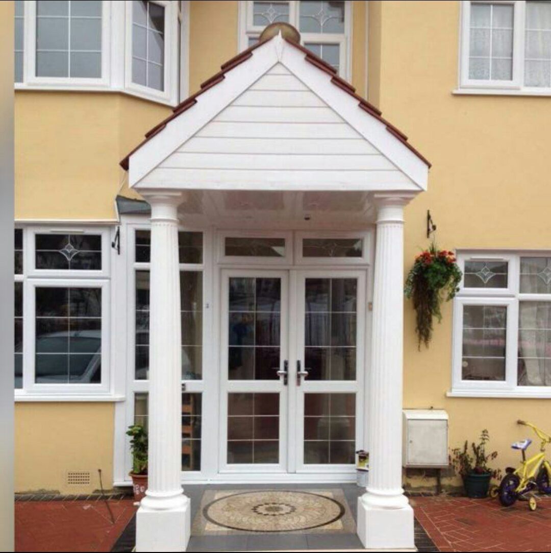 A yellow house with a white porch and white doors