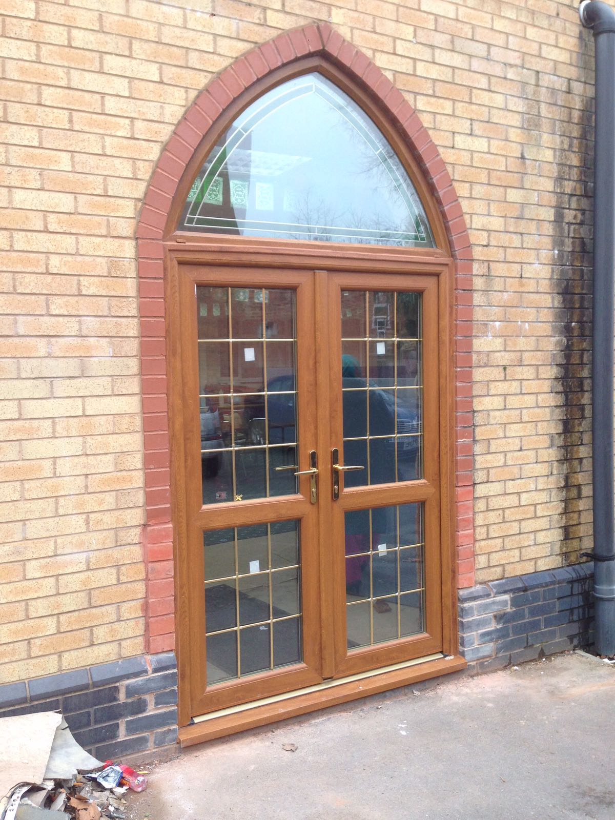 A wooden door is on the side of a brick building.