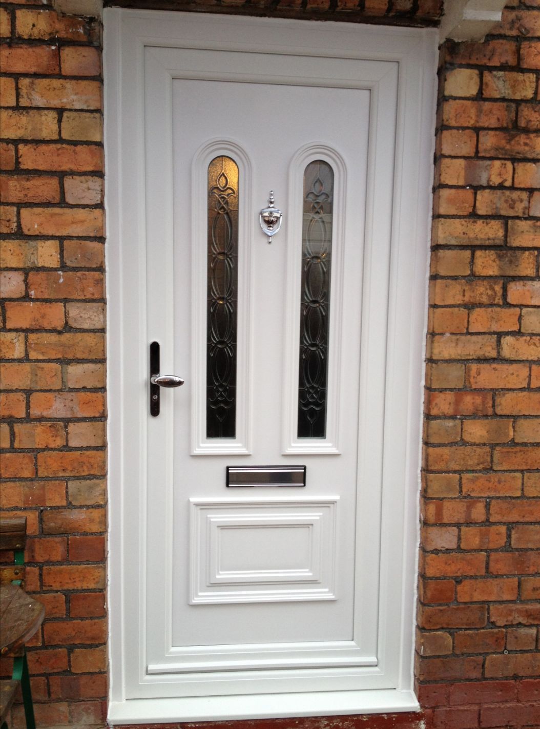 A white door is sitting on a brick wall.