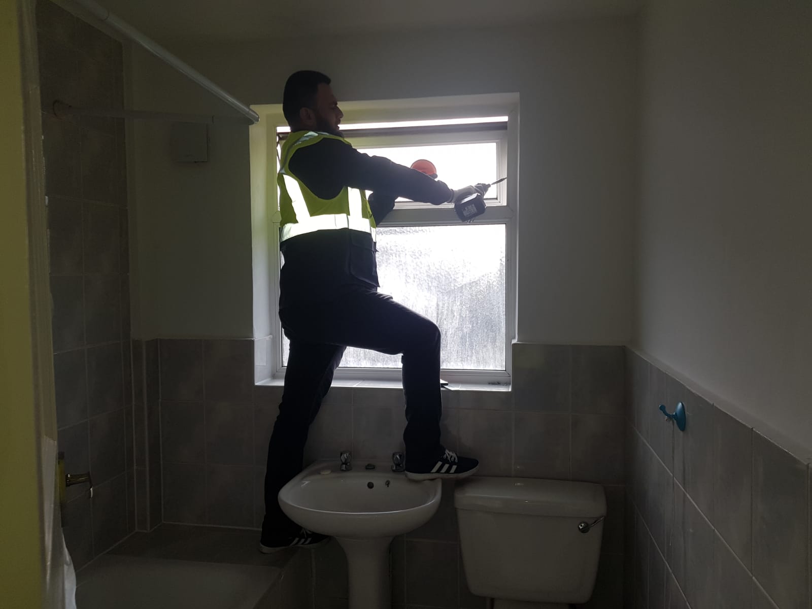 A man repairing window in a bathroom