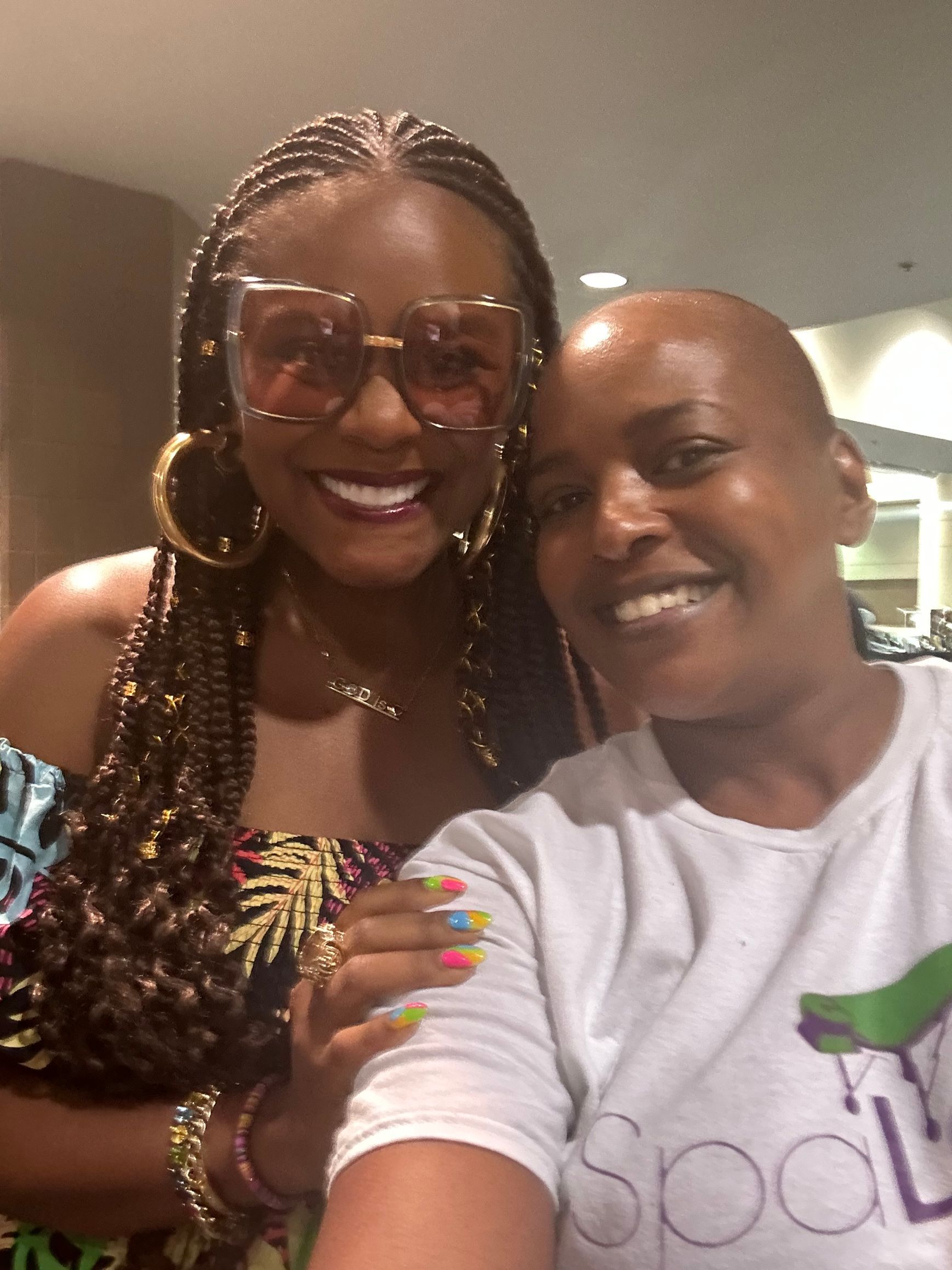 Two women posing for a picture with one wearing a shirt that says spa