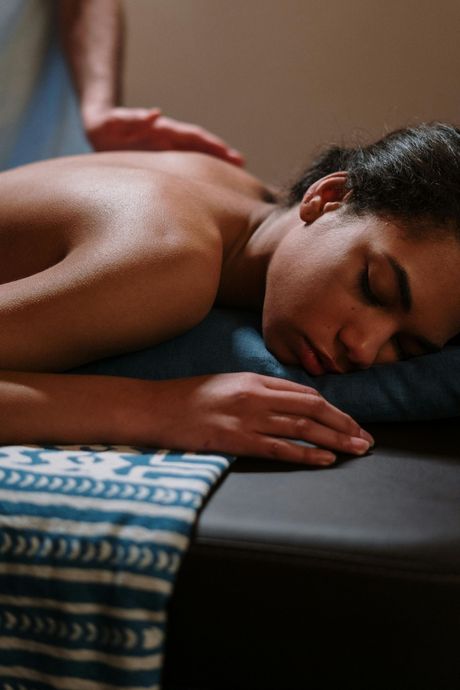 A woman is laying on a table getting a massage.