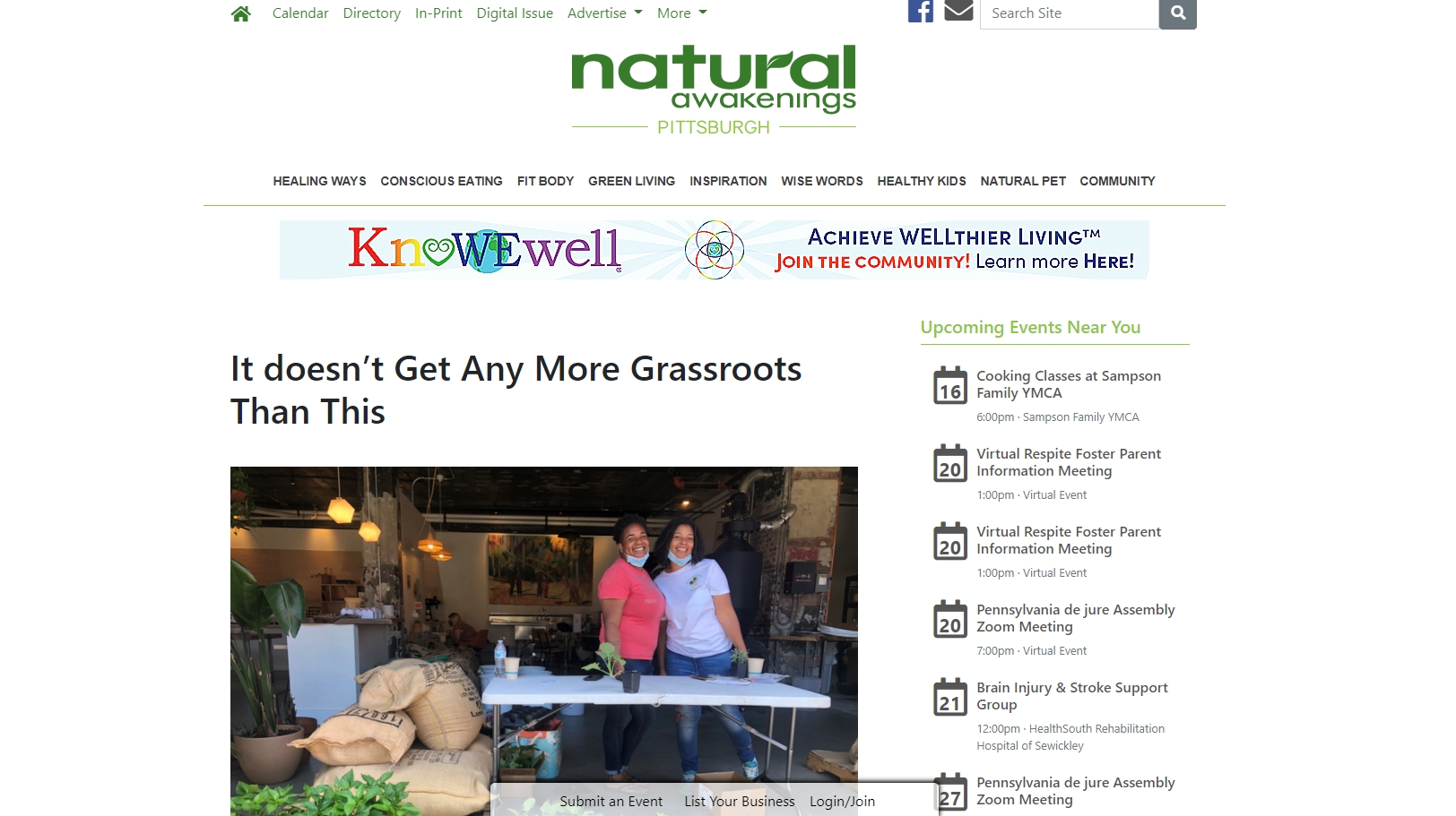 A couple of people standing next to each other in front of a table.