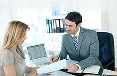 Man and woman talking at a desk